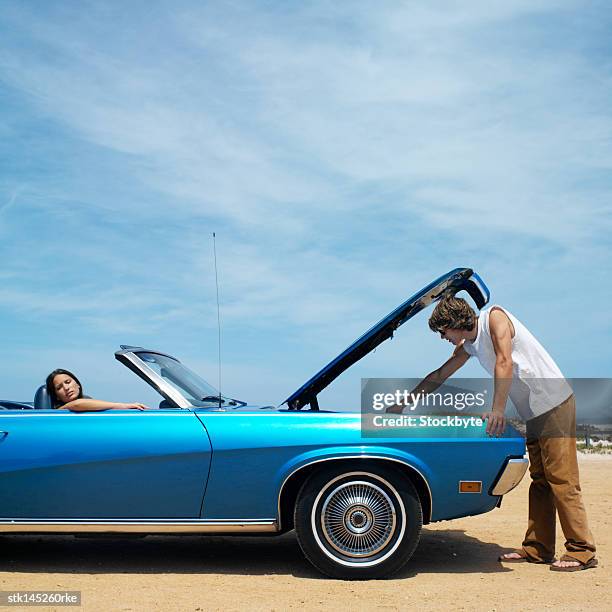 young couple driving in convertible car hood raised - hood clothing stock pictures, royalty-free photos & images