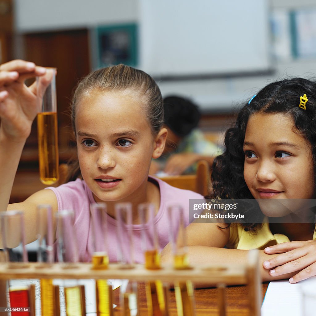 Portrait of two young girls working with a rack of test tubes