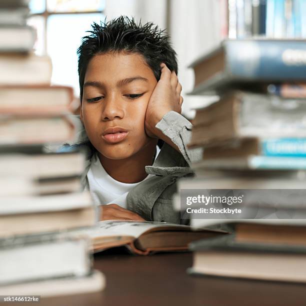 portrait of a young boy studying beside a pile of books - donald trump holds campaign rally in nc one day ahead of primary stockfoto's en -beelden