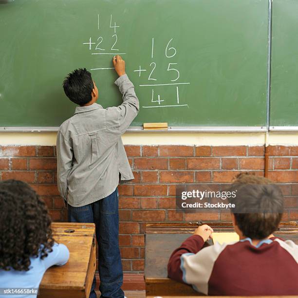 back of a schoolboy doing math for the class on the chalkboard - donald trump holds campaign rally in nc one day ahead of primary stockfoto's en -beelden