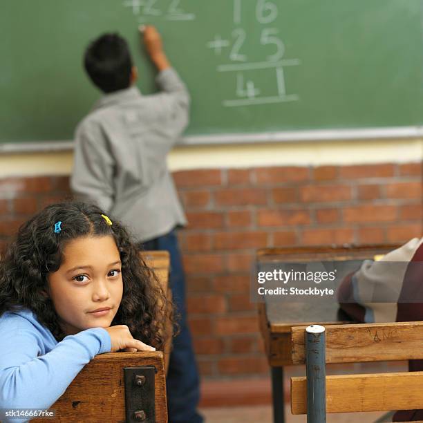 portrait of girl sitting inside a classroom - inside of ストックフォトと画像