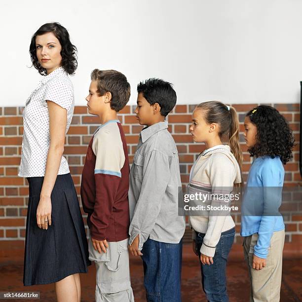 side profile of a school teacher and students standing in a single line - donald trump holds campaign rally in nc one day ahead of primary stockfoto's en -beelden