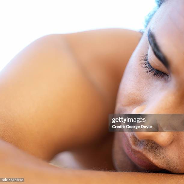 young man lying on massage table head shot closed eyes close up - massage table white background stock pictures, royalty-free photos & images