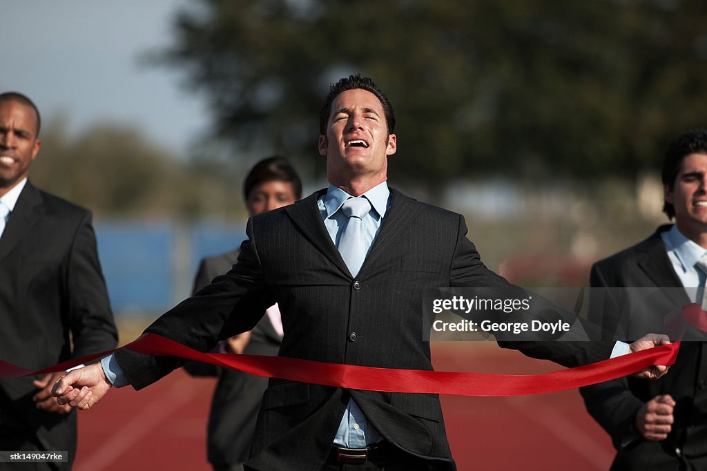 Businesspeople running towards finish line