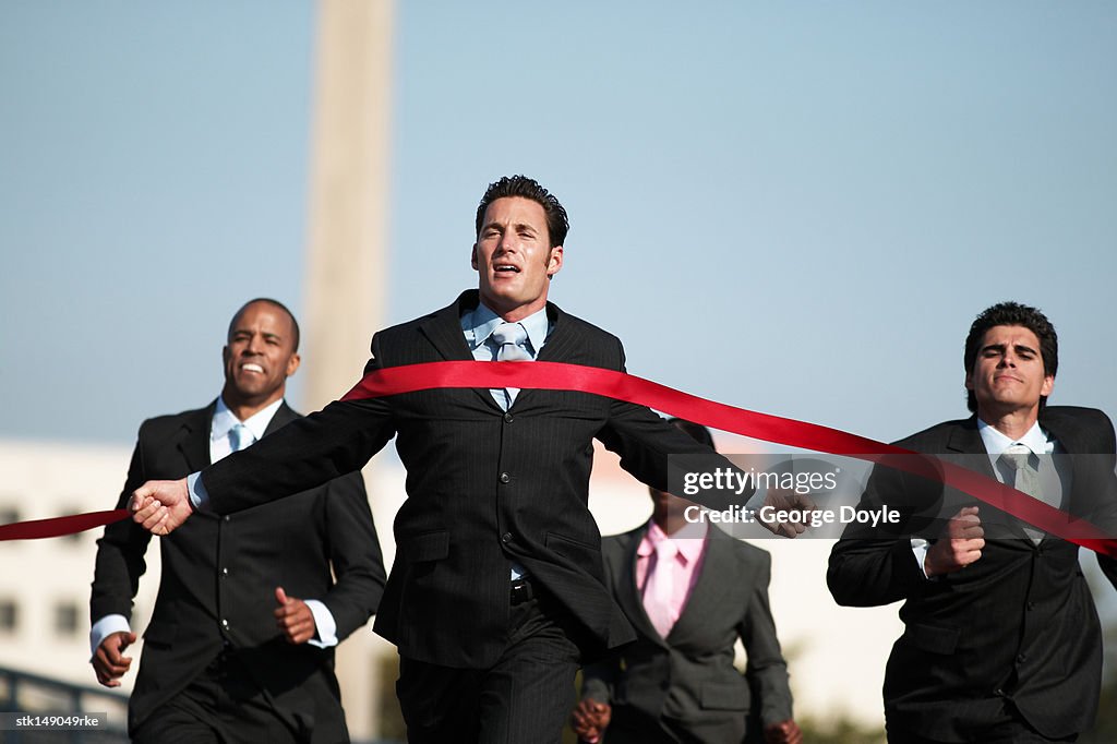 Businesspeople running towards finish line low angle view