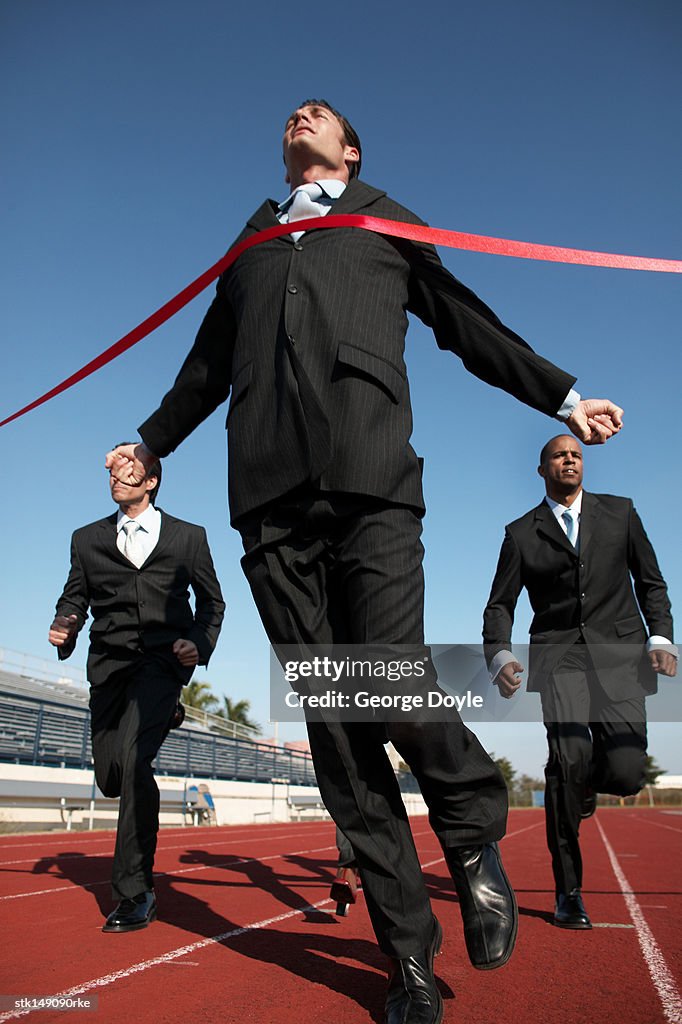 Businesspeople running towards finish line low angle view