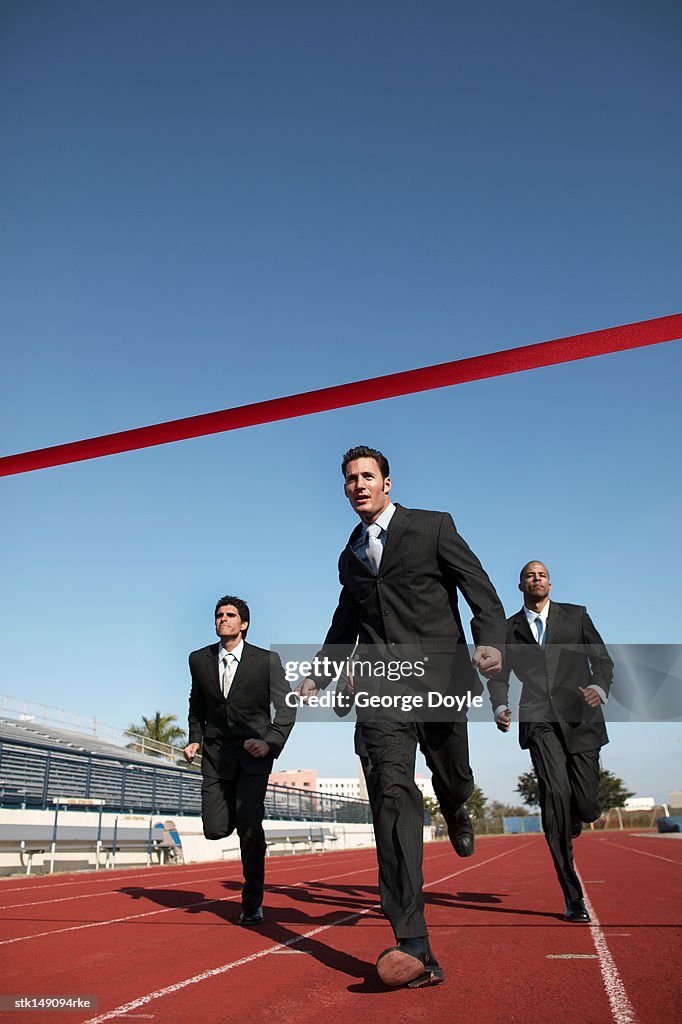 Businesspeople running towards finish line low angle view
