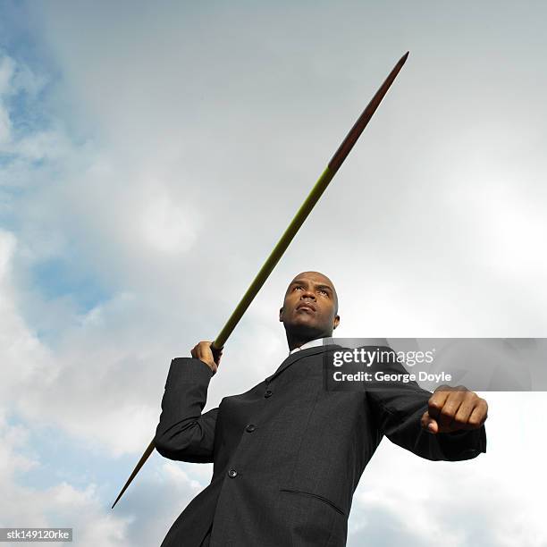 low angle view of a businessman throwing a javelin - men's field event stock pictures, royalty-free photos & images