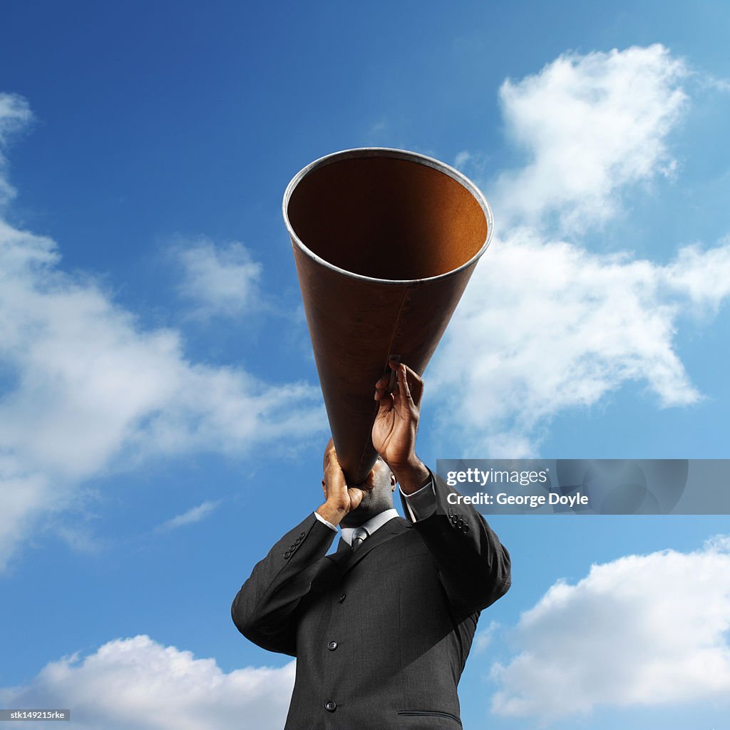 Low angle view of a man holding a loudspeaker