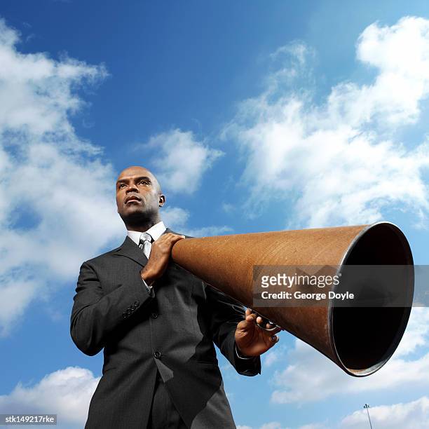 low angle view of a man holding a loudspeaker - angry bald screaming man ストックフォトと画像