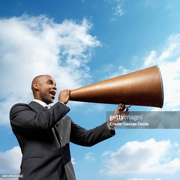 businessman talking through megaphone, low angle view - low motivation stock pictures, royalty-free photos & images