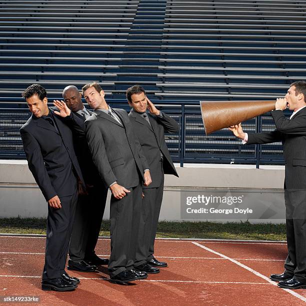 businessman talking through megaphone to businesspeople, side view - informational stock pictures, royalty-free photos & images