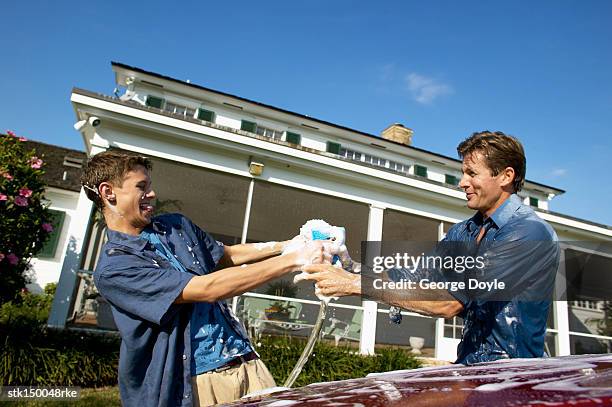 father and teenage son (18-20) washing a car together - teen wash car stock pictures, royalty-free photos & images