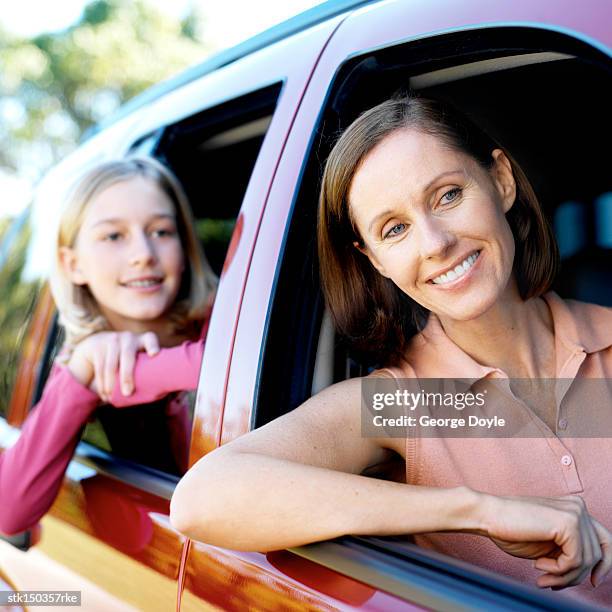 portrait of a mother and daughter looking out of the car window together - daughter car stock pictures, royalty-free photos & images