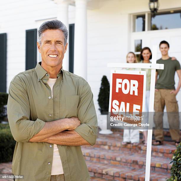 portrait of a man standing next to a 'for sale' sign - for sale stockfoto's en -beelden