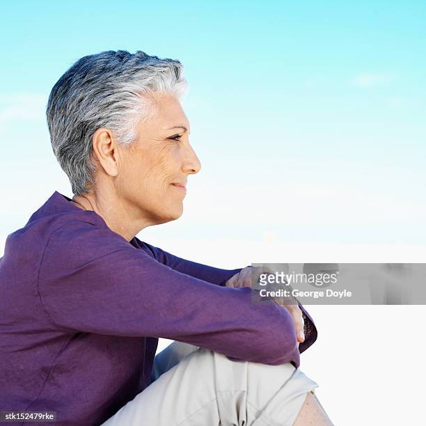 side profile of an elderly woman sitting down looking ahead - get ahead stock-fotos und bilder