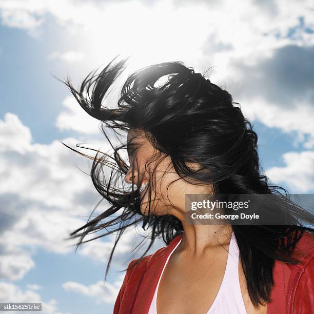 side profile of a young woman smiling with hair across her face - across stock pictures, royalty-free photos & images