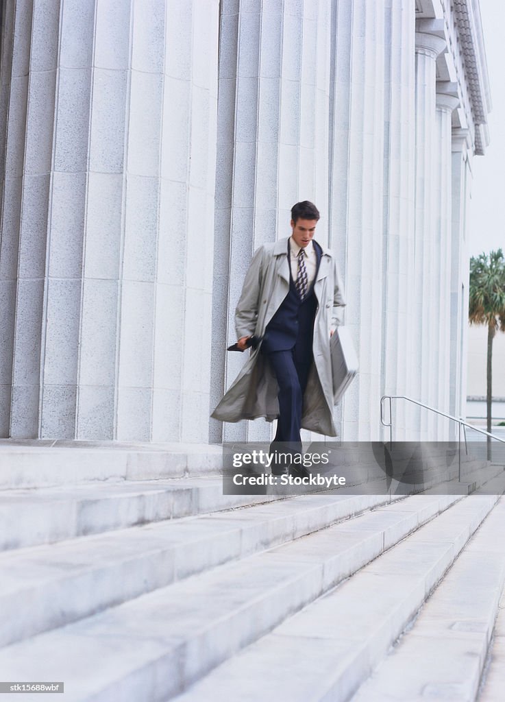 Portrait of a young businessman running down stairs