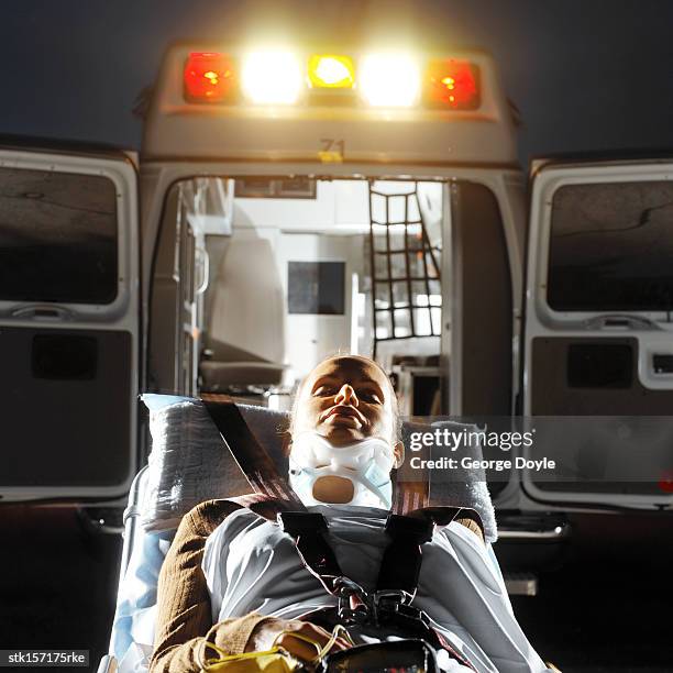 an accident victim lying on a gurney behind an ambulance - hospital gurney stock pictures, royalty-free photos & images