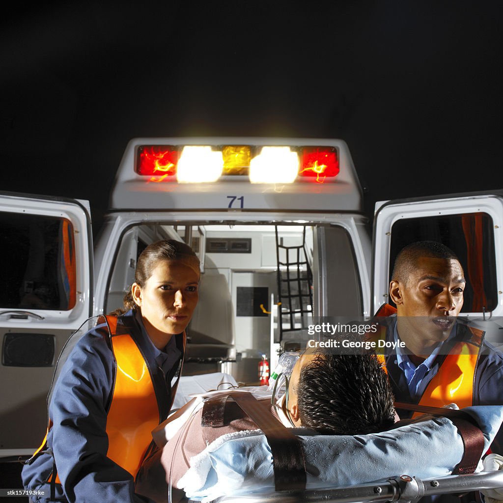 Paramedics rushing a patient to the ambulance