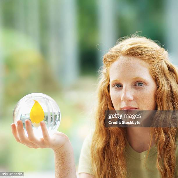 portrait of a young girl (14-16) with a crystal ball with a flower inside - crystal - fotografias e filmes do acervo