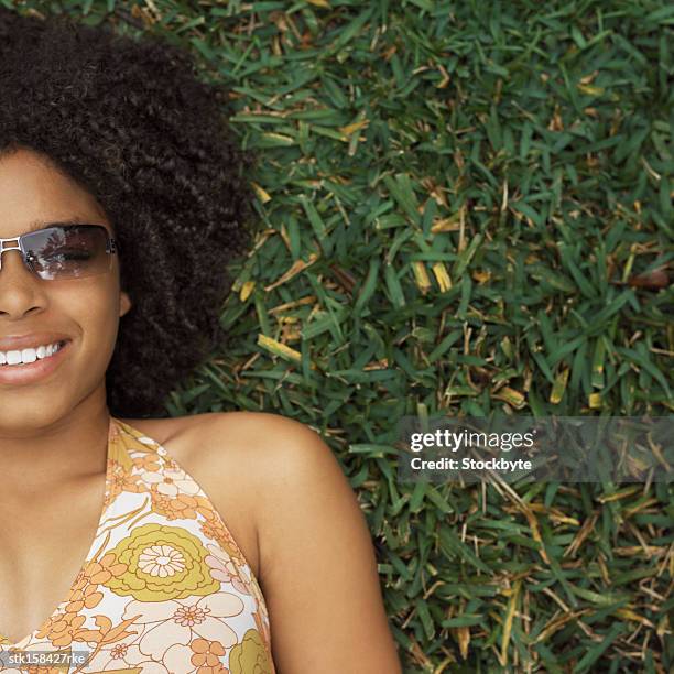 elevated view of a teenage girl (17-18) lying on the grass with sunshades - square neckline fotografías e imágenes de stock