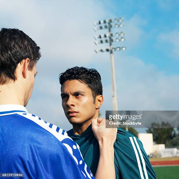 confrontation between two male (16-20) soccer players - between stock-fotos und bilder
