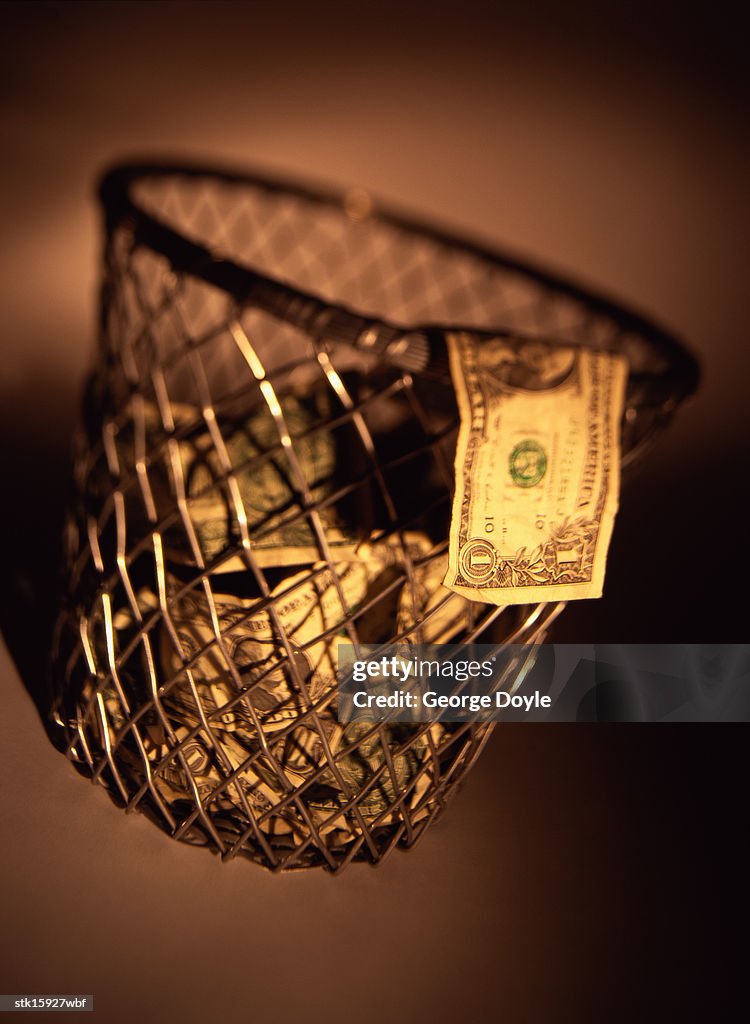 Close-up of money thrown in a waste paper basket