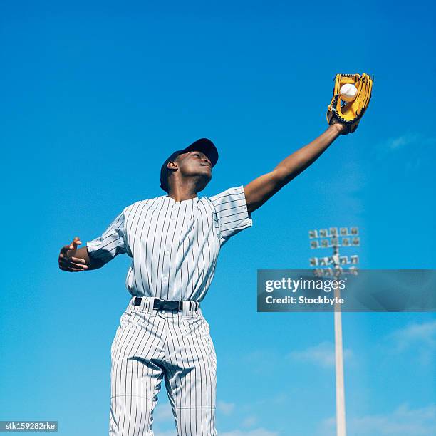 baseball player (16-20) catching ball in baseball glove - catch 22 stock-fotos und bilder