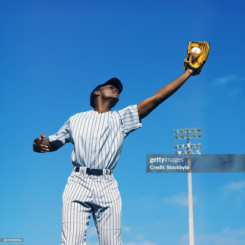Baseball player (16-20) catching ball in baseball glove