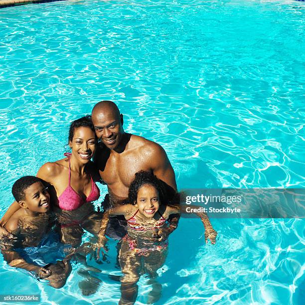 two generation family standing in swimming-pool - preteen girl no shirt stock pictures, royalty-free photos & images