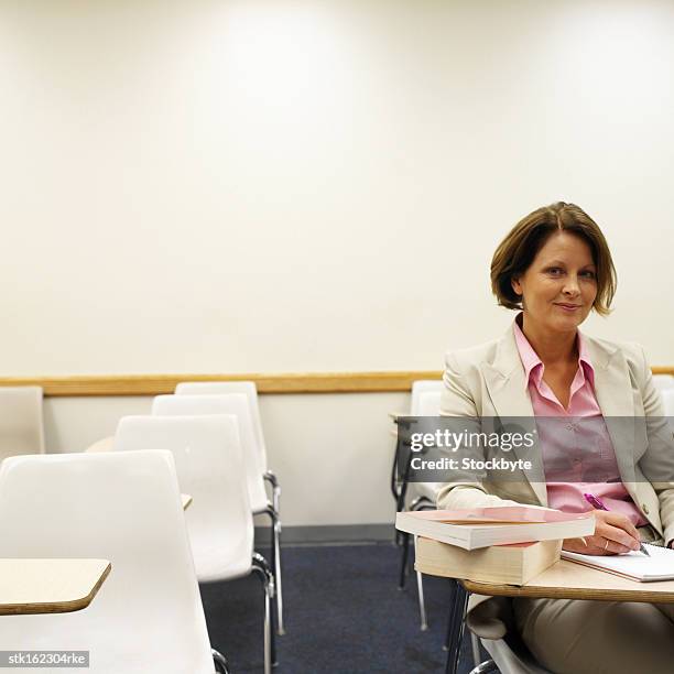 young woman sitting at her desk in class - university of california students protest 32 percent fee hike stockfoto's en -beelden