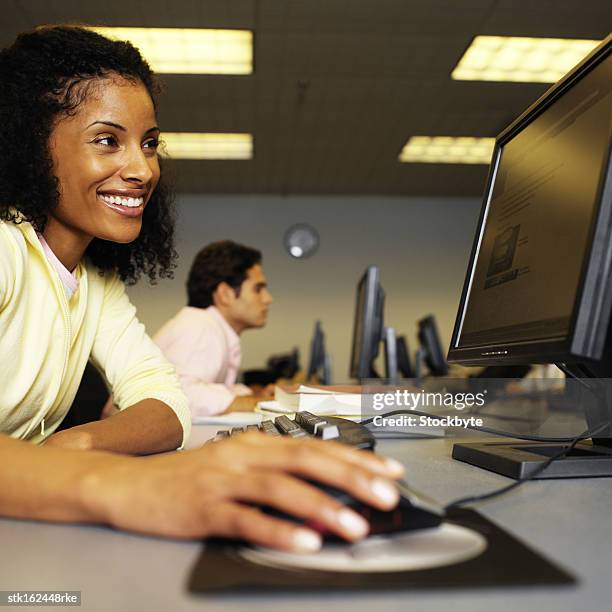 side profile of a young woman working on a computer - university of california students protest 32 percent fee hike stockfoto's en -beelden