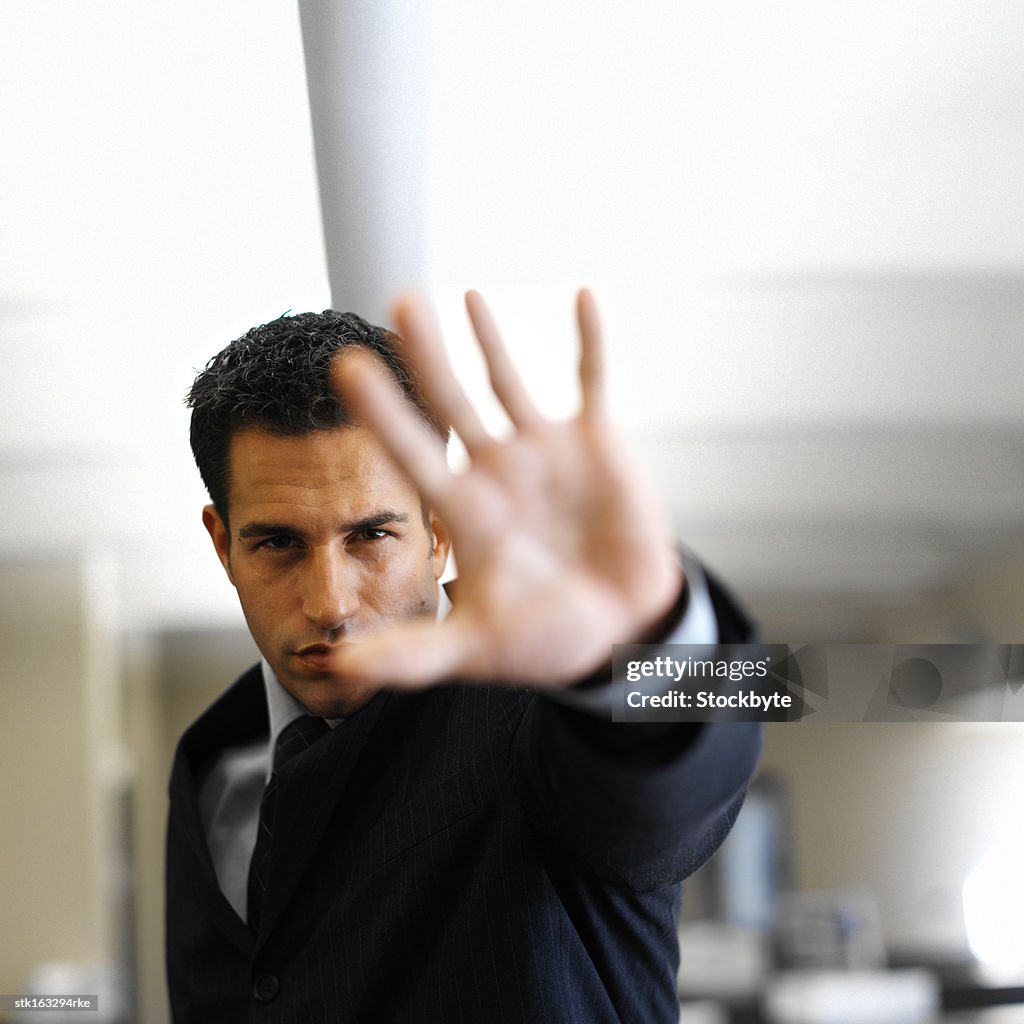 Businessman holding hand up in front of camera close-up