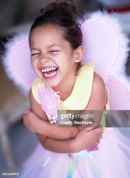 portrait of a young girl (6-8) dressed as an angel; grinning - angel white dress stock-fotos und bilder