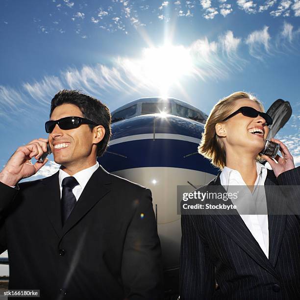 business executives standing in front of an airplane and talking on mobile phones - meek mill supporters protest on day of status hearing stockfoto's en -beelden