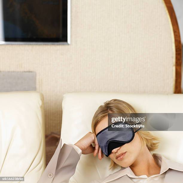 close up of businesswoman sleeping wearing eye mask - business class reclining plane stock pictures, royalty-free photos & images