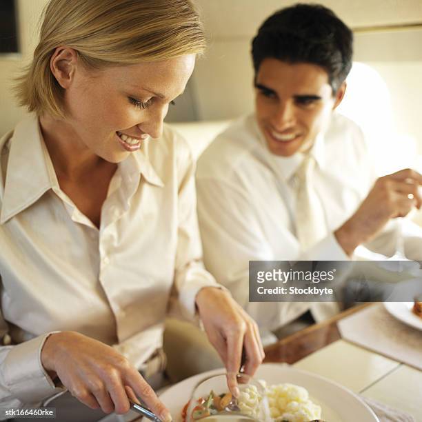 business executives eating and drinking in an airplane - yuppie stock-fotos und bilder