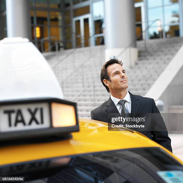 close up of businessman standing beside taxi in the street - open roads world premiere of mothers day arrivals stockfoto's en -beelden