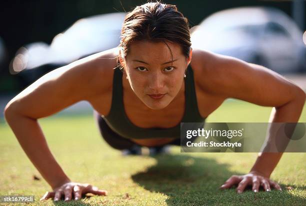 portrait of a young woman doing push ups - duing stock pictures, royalty-free photos & images