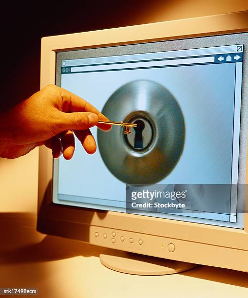 a person holding a key up to a screen which is displaying a key hole - is stock pictures, royalty-free photos & images