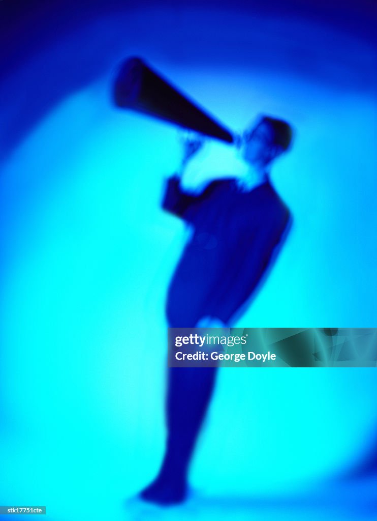 Tungsten toned side profile of a man speaking into a loudspeaker; blurred