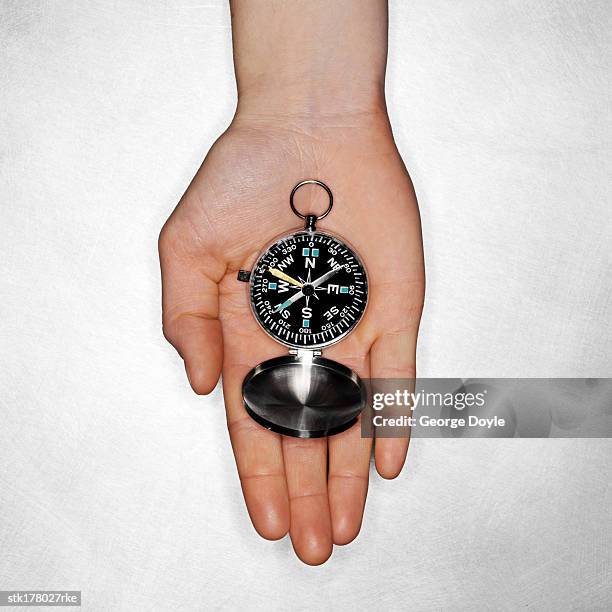 a navigational compass displayed on a hand - travel7 stock pictures, royalty-free photos & images