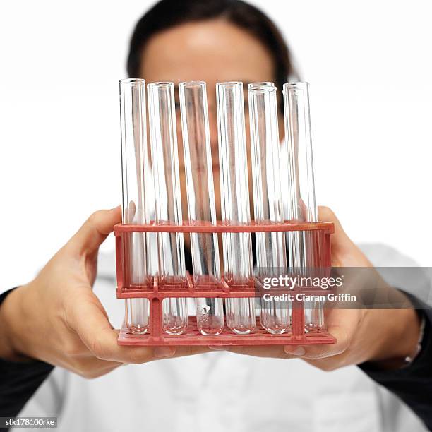 a person holding a test tube rack - test tube rack stock pictures, royalty-free photos & images