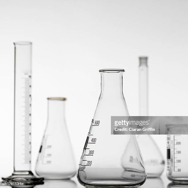a variety of glass beakers and test tubes placed on a table - mätglas bildbanksfoton och bilder