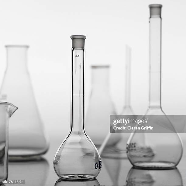 a variety of glass beakers placed on a table - variety fotografías e imágenes de stock