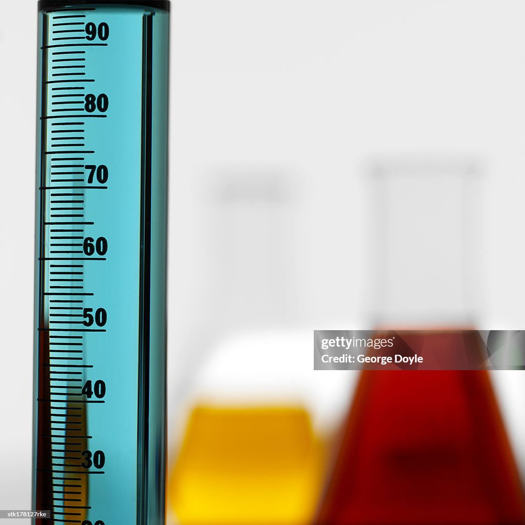 Test tube holding a blue liquid placed with two beakers