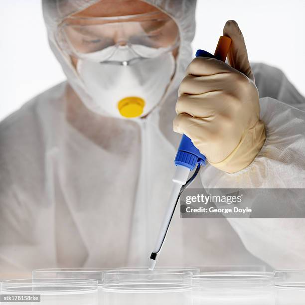 scientist in full protective gear using a pipette - unveiling of life size statue of andrea bocelli at keep memory alive event center stockfoto's en -beelden
