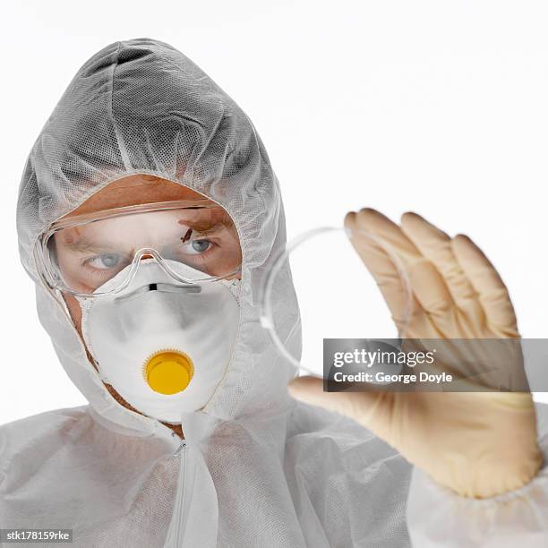 scientist in full protective gear holding up a petri dish - unveiling of life size statue of andrea bocelli at keep memory alive event center stockfoto's en -beelden