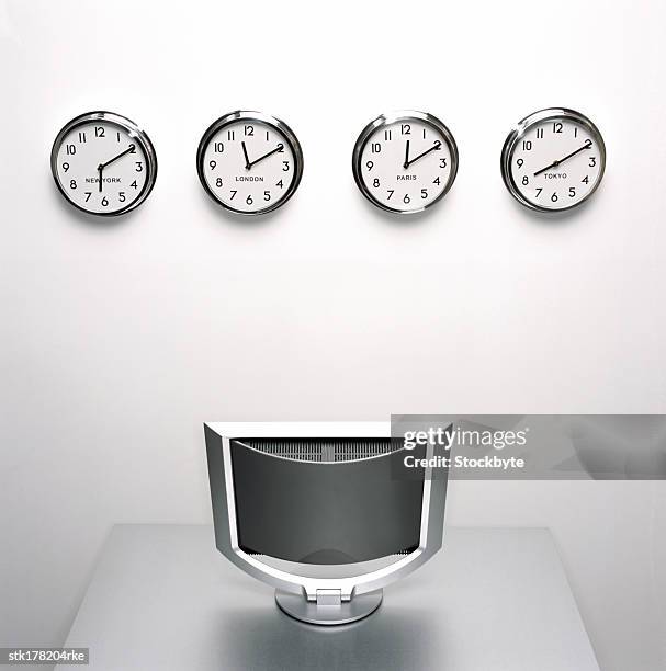 an array of wall clocks displaying world time - world time clocks stock pictures, royalty-free photos & images